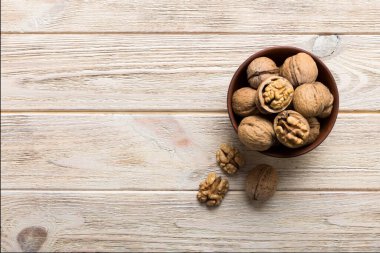 Fresh healthy walnuts in bowl on colored table background. Top view Healthy eating bertholletia concept. Super foods.