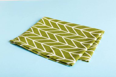 top view with green kitchen napkin isolated on table background. Folded cloth for mockup with copy space, Flat lay. Minimal style.