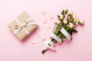 Pembe gül çiçekli tasarım konsepti ve renkli masa arkası manzaralı hediye kutusu. Mutlu Noeller, Anneler Günü, doğum günü konsepti. Romantik düz konum.