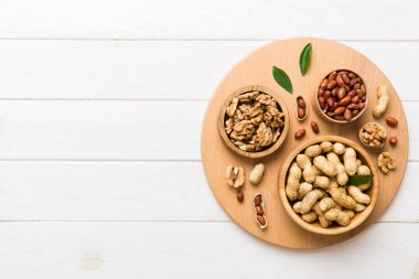 Ceviz çekirdeği yarım, ahşap bir kasede. Yakın plan, yukarıdan, renkli arkaplanda. Sağlıklı beslenme kavramı. Kopyalama alanı olan süper gıdalar.