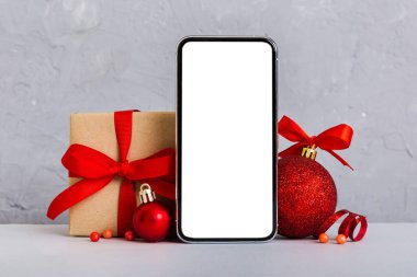 Digital phone mock up with rustic Christmas decorations for app presentation with empty space for you design. Christmas online shopping concept. Tablet with copy space on colored background.