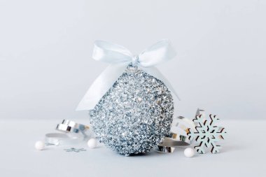 Christmas ball on colored background. decoration bauble with ribbon bow with copy space.