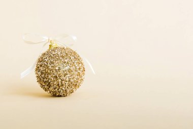 Christmas ball on colored background. decoration bauble with ribbon bow with copy space.