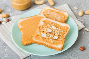 Fıstık ezmeli sandviç ya da arka planda kızarmış ekmek. Kahvaltı. Vejetaryen yemeği. Amerikan mutfağının üst görünümü kopyalama alanı.