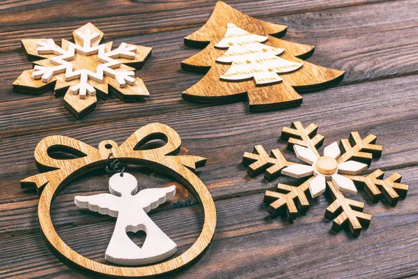 Christmas snowflakes, Christmas tree and angel in a frame on a wooden background. New Year wooden decorations. Toned.