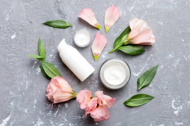 Kozmetik ürünleri ve çimento arka planında güzel güller olan kompozisyon. Düz yatıyordu.