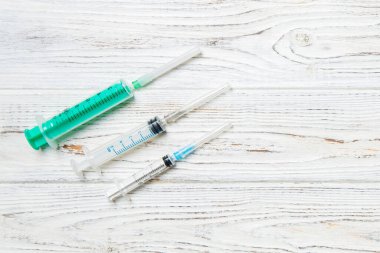 Ahşap arka planda farklı boyutlarda şırıngaların üst görüntüsü. Fotokopi alanı ile enjeksiyon konsepti için tıbbi ekipman.