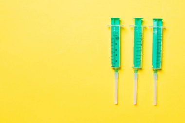 Renkli arkaplanda fotokopi alanı olan tıbbi enjeksiyon için üst sıradaki şırıngaların görüntüsü. Sağlık ve aşı kavramı.