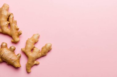 Renkli arka planda yeşil yapraklı kabın içinde zencefil tozu var. Üst görünüm düzlüğü.