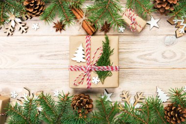 Noel köknar ağacı ve hediye kutusu ahşap masa üzerinde arka plan. Tasarımınız için kopya alanı ile üstten görünüm.
