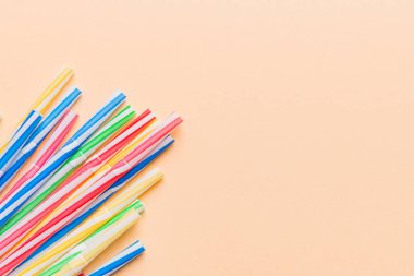 Renkli arka planda renkli plastik pipetler, düz yatış. Metin için Boşluğu Kopyala.