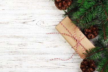 Noel kompozisyon geçmişi. Noel hediyesi olarak çam kozalakları ve tahta arka planda köknar dalları. Düz konum, üst görünüm, kopyalama alanı. Ayarlanmış.