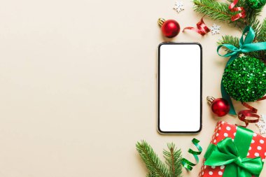 Digital phone mock up with rustic Christmas decorations for app presentation top view with empty space for you design. Christmas online shopping concept. Tablet with copy space on colored background.