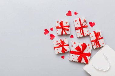 Gift boxes pop out from paper bag top view on colored background. bag packing handmade boxes fall out Concept of holidays, shopping, sale, discounts. Top view, flat lay.