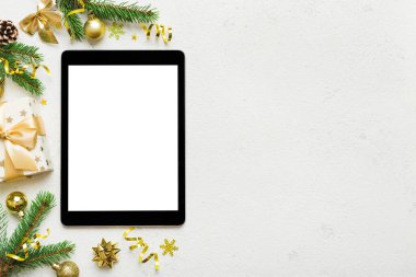 Digital tablet mock up with rustic Christmas decorations for app presentation top view with empty space for you design. Christmas online shopping concept. Tablet with copy space on colored background.