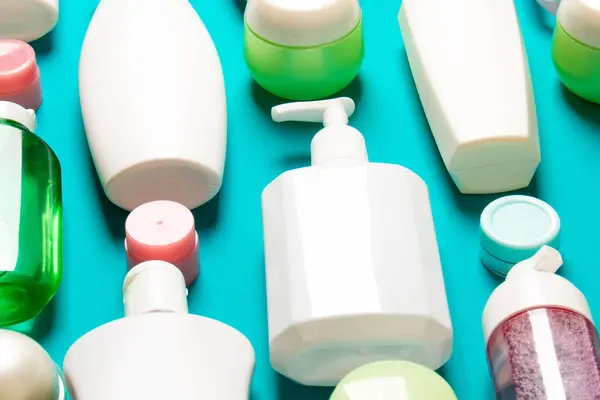 Top view of different cosmetic bottles and container for cosmetics on colored background. Flat lay composition with copy space.