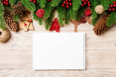 Defterin üst görüntüsü, Noel oyuncakları, dekorasyonlar ve tahta arka planda köknar ağacı dalları. Yeni yıl tatili konsepti.