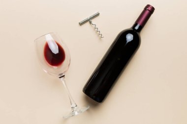 Tirbuşonlu düz kompozisyon, bir şişe şarap ve renkli masada zarif bir cam. Düz konum, üst görünüm kopyalama alanı.