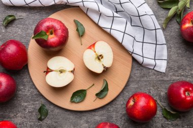 Yeşil yapraklı taze kırmızı elmalar. Bıçakla kesme tahtası. Üst görünüm.