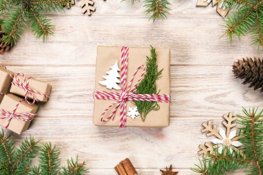 Noel köknar ağacı ve hediye kutusu ahşap masa üzerinde arka plan. Tasarımınız için kopya alanı ile üstten görünüm.