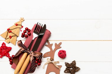 Noel süslemeleri ve ahşap arka planda ren geyiği olan peçetedeki yeni yıl aletlerinin en üst görüntüsü. Fotokopi alanı ile Noel yemeği konsepti.