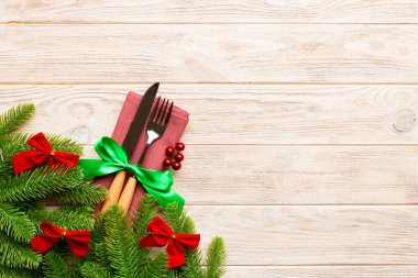 Ahşap arka planda noel süslerinin en üst görüntüsü. Peçetedeki çatal ve bıçak kurdeleyle bağlanmış ve senin tasarımın için boş bir alan. Yeni yıl şablonu kavramı.