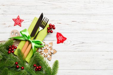 Ahşap arka planda noel süslerinin en üst görüntüsü. Peçetedeki çatal ve bıçak kurdeleyle bağlanmış ve senin tasarımın için boş bir alan. Yeni yıl şablonu kavramı.