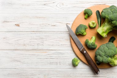Tahta kesme tahtasının üzerinde bıçakla taze yeşil brokoli. Brokoli lahana yaprakları. Hafif arkaplan. Düz yatıyordu.