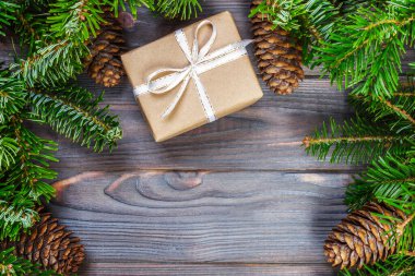 Ahşap arkaplan görünümünde köknar dalları olan hediye kutuları.