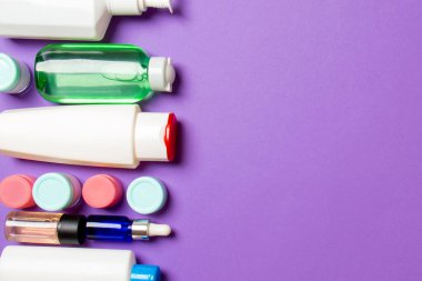 Renkli arka planda kozmetik şişelerinin üst görüntüsü. Tasarımınız için alanı olan cilt bakımı kavramı.