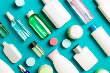 Plastik gövde bakımı şişesi düz kompozisyonu ve renkli arka plan boşluğuna kozmetik ürünler dizayn edilmişti. Beyaz Kozmetik kapları kümesi, kopya alanı ile üst görünüm.