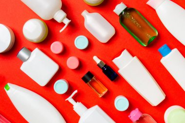 Plastik gövde bakımı şişesi düz kompozisyonu ve renkli arka plan boşluğuna kozmetik ürünler dizayn edilmişti. Beyaz Kozmetik kapları kümesi, kopya alanı ile üst görünüm.