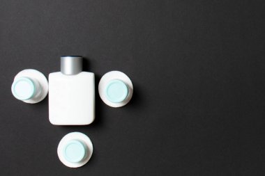 Renkli arka planda seyahat etmek için bir grup küçük şişe. Fikirlerin için uzayı kopyala. Kozmetik ürünlerin düz bileşimi. Pamuklu krema kaplarının üst görüntüsü.