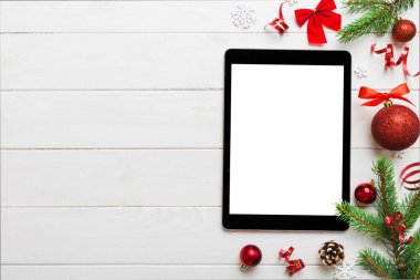 Digital tablet mock up with rustic Christmas decorations for app presentation top view with empty space for you design. Christmas online shopping concept. Tablet with copy space on colored background.