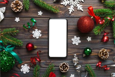 Digital phone mock up with rustic Christmas decorations for app presentation top view with empty space for you design. Christmas online shopping concept. Tablet with copy space on colored background.
