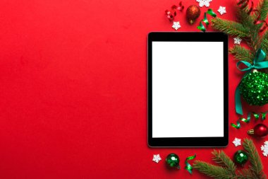 Digital tablet mock up with rustic Christmas decorations for app presentation top view with empty space for you design. Christmas online shopping concept. Tablet with copy space on colored background.