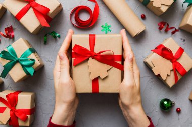 Kadın eli hediye kutusunu tutuyor, sürprizi hazırlıyor, üst manzara, Noel ve yeni yıl konsepti.