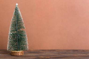 One small Christmas tree on colored background. new year decoration with copy space.