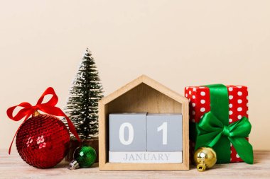 25 december. Christmas composition on colored background with a wooden calendar, with a gift box, toys, bauble copy space.