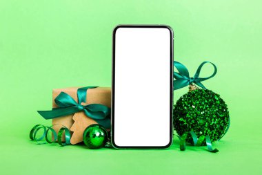 Digital phone mock up with rustic Christmas decorations for app presentation with empty space for you design. Christmas online shopping concept. Tablet with copy space on colored background.