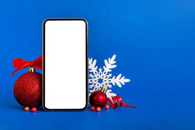 Digital phone mock up with rustic Christmas decorations for app presentation with empty space for you design. Christmas online shopping concept. Tablet with copy space on colored background.