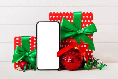 Digital phone mock up with rustic Christmas decorations for app presentation with empty space for you design. Christmas online shopping concept. Tablet with copy space on colored background.