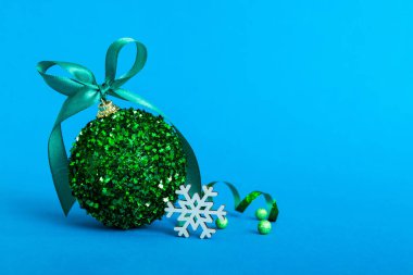Christmas ball on colored background. decoration bauble with ribbon bow with copy space.
