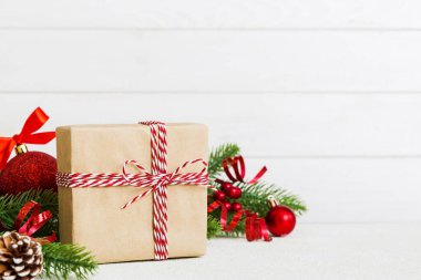 New Year Christmas mood, gift box, branches of a christmas tree, New Year decorations on a colored background.