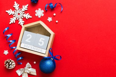 Christmas calendar 25 december. Christmas gift, fir branches, pine cones. Flat lay, top view. New Year decorations on a colored background.