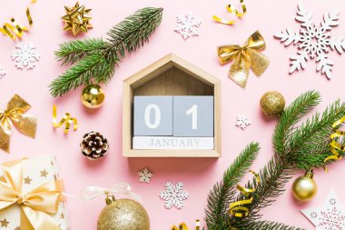 Christmas calendar 1 january. Christmas gift, fir branches, pine cones. Flat lay, top view. New Year decorations on a colored background.