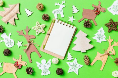 Noel oyuncakları ve dekorasyonlarla dolu yeşil bir arka plan. Defterin en üst görüntüsü. Mutlu yıllar konsepti.