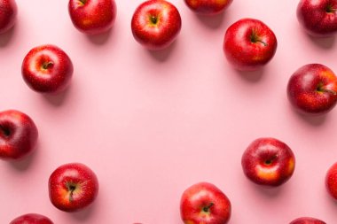 Renkli arka planda bir sürü kırmızı elma, üst manzara. Tasarım veya metin için kopyalama alanı olan taze elma görünümlü sonbahar deseni.