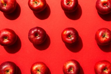 Renkli arka planda bir sürü kırmızı elma, üst manzara. Görüş üzerinde taze elma ile sonbahar deseni.