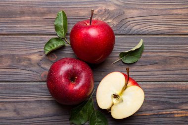 Tahta masada yeşil yapraklı taze kırmızı elmalar. Ahşap arka planda. Metin için üst görünüm boş alanı.